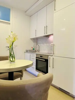 a kitchen with a table with a vase of flowers on it at Nora Apartment in Budva