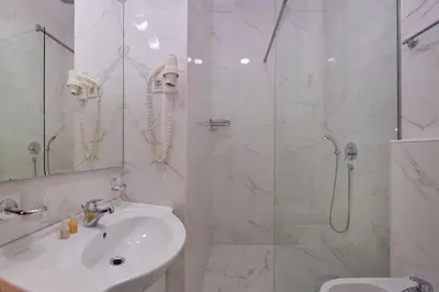 a white bathroom with a shower and a sink at Shine Crystal, first line with a stunning view in Čučići