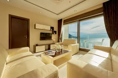 a living room with white furniture and a large window at Shine Crystal, first line with a stunning view in Čučići