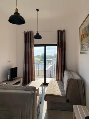 a living room with a couch and a tv and a balcony at Imperial Family Resort in Ulcinj