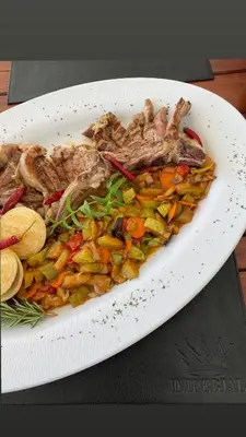 a plate of food with meat and vegetables on a table at Imperial Family Resort in Ulcinj