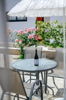 a table with a bottle of wine and two glasses at Imperial Family Resort in Ulcinj