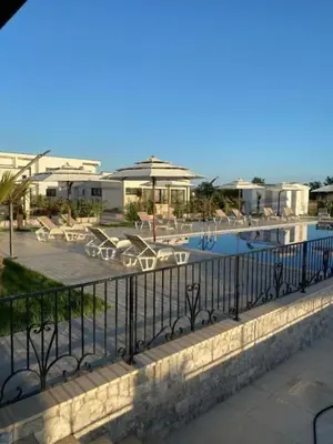 a resort with a swimming pool with chairs and umbrellas at Imperial Family Resort in Ulcinj