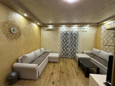 a living room with two couches and a clock on the wall at Lux Apartment Oasis in Rafailovici