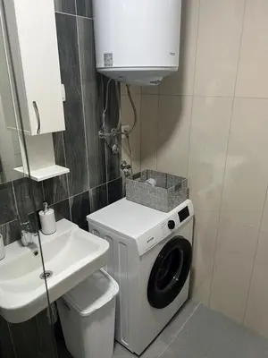 a bathroom with a washing machine and a sink at Adriatic apartman in Budva