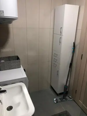 a kitchen with a mop next to a white refrigerator at Adriatic apartman in Budva