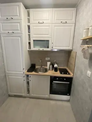 a small kitchen with white cabinets and a sink at Adriatic apartman in Budva