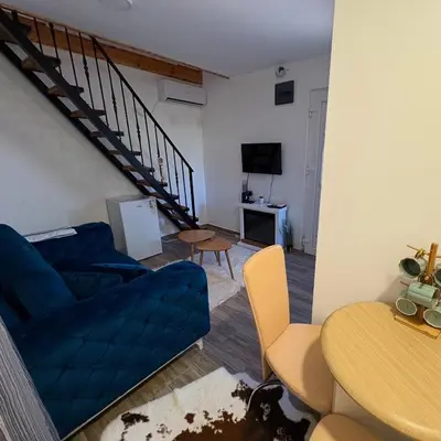 a living room with a blue couch and a table at Tiny house 1 - Imanje Terzic in Podgorica