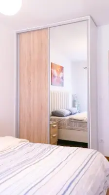 a bedroom with a large mirror and a bed at Ana Lux Master apartament in Podgorica