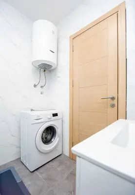 a washer and dryer in a kitchen with a door at Comfort apartment Becici by In Property in Becici