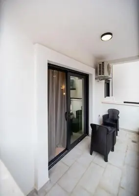 a living room with two chairs and a white wall at Comfort apartment Becici by In Property in Becici