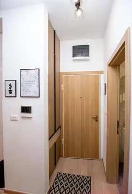 a hallway with a wooden door and a rug at Comfort apartment Becici by In Property in Becici