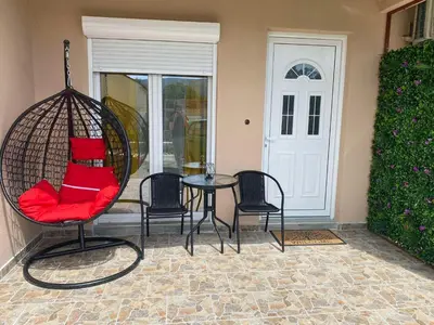 a porch with a swing with a table and chairs at OLGA APARTMENT in Kotor