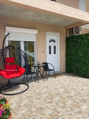 a patio with a swing and a table and a door at OLGA APARTMENT in Kotor