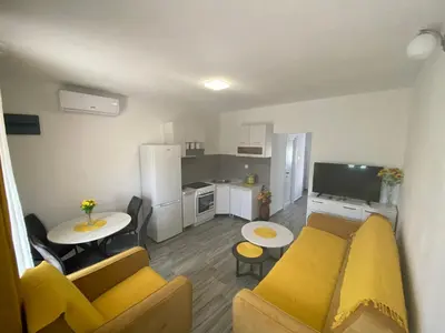 a living room with a couch and a kitchen at OLGA APARTMENT in Kotor