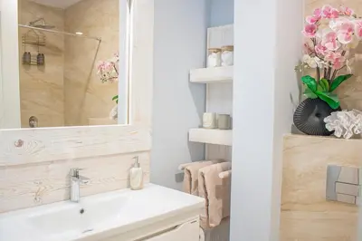 a bathroom with a sink and a mirror and flowers at The Dream Getaway SkyLine by DeVasco in Becici