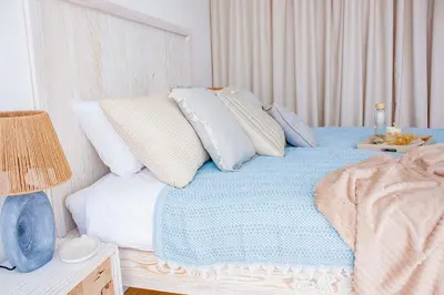 a bedroom with a bed with blue and white pillows at The Dream Getaway SkyLine by DeVasco in Becici