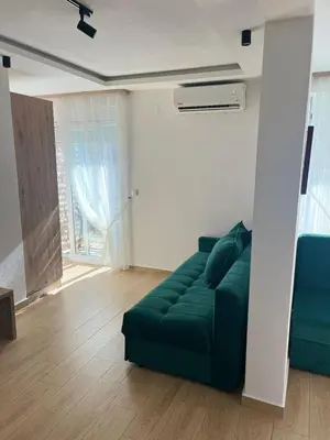 a living room with a green couch and a window at Hotel NOBEL Ulcinj in Ulcinj