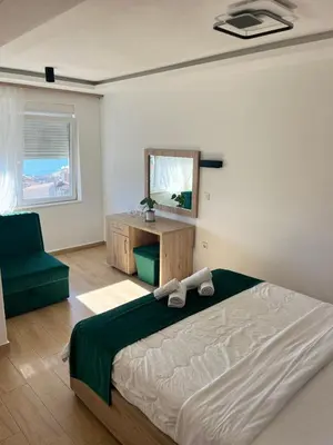 a bedroom with a bed and a mirror and a chair at Hotel NOBEL Ulcinj in Ulcinj