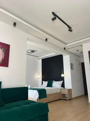 a bedroom with a bed and a green couch at Hotel NOBEL Ulcinj in Ulcinj