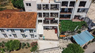 an overhead view of a white building with a swimming pool at Hotel NOBEL Ulcinj in Ulcinj