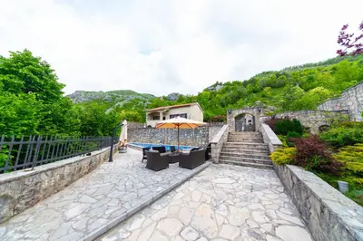 a patio with a table and an umbrella and stairs at Blake's Villa in Budva