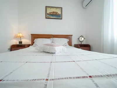 a bedroom with a white bed with two night stands at Casa Pastrovici del Mare in Petrovac na Moru