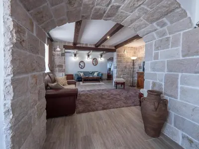 a large living room with a stone wall at Casa Pastrovici del Mare in Petrovac na Moru