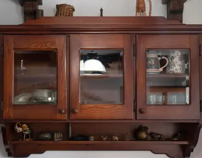 a wooden cabinet with glass doors with dishes in it at Casa Pastrovici del Mare in Petrovac na Moru
