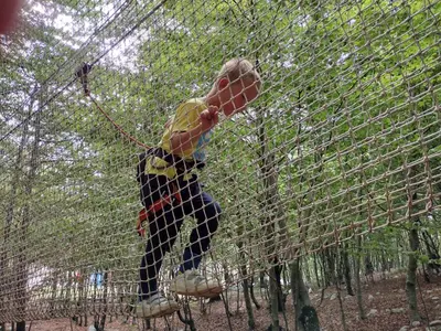 a boy on a zip line in a batting cage at Appartment Belavista in Bar
