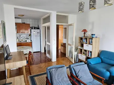a living room with a blue couch and a kitchen at Appartment Belavista in Bar