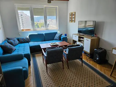a living room with a blue couch and a table at Appartment Belavista in Bar