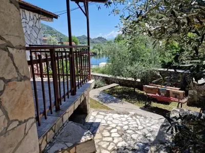 a fence on the side of a house with a lake at Lakeside oasis home Karuc in Karuč