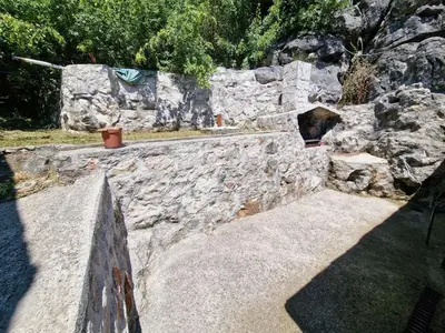 a stone retaining wall with a stone stairway at Lakeside oasis home Karuc in Karuč