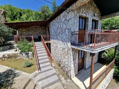 a stone house with stairs and a balcony at Lakeside oasis home Karuc in Karuč
