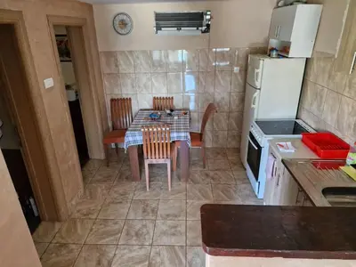 a small kitchen with a table and a refrigerator at Lakeside oasis home Karuc in Karuč