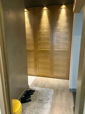 a hallway with wooden closets and a rug at smgold lux apartman in Podgorica