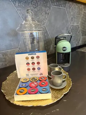 a box of donuts sitting on a table next to cups at smgold lux apartman in Podgorica