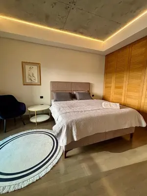 a bedroom with a large bed and a table at smgold lux apartman in Podgorica