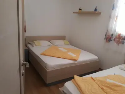a small bedroom with a bed with white sheets at APARTMAN PAVLE in Petrovac na Moru