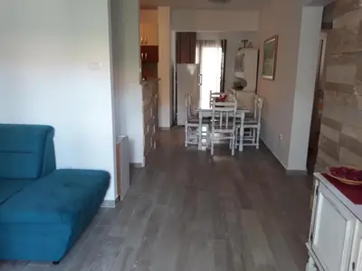 a living room with a blue couch and a table at APARTMAN PAVLE in Petrovac na Moru