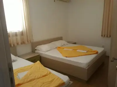 two twin beds in a small room with a window at APARTMAN PAVLE in Petrovac na Moru