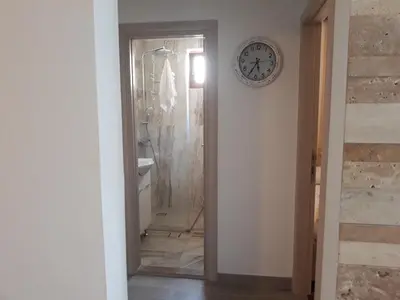 a bathroom with a clock on the wall next to a mirror at APARTMAN PAVLE in Petrovac na Moru