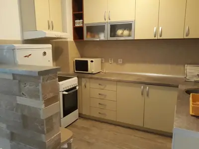 a kitchen with white cabinets and a microwave at APARTMAN PAVLE in Petrovac na Moru