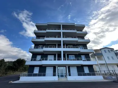a tall apartment building with a blue at sunsetmontenegro in Utjeha