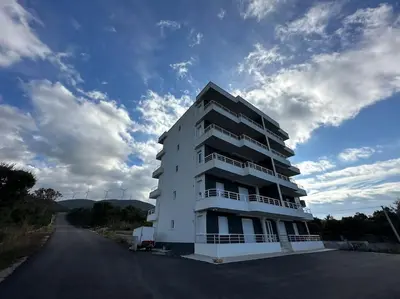 a white apartment building on the side of a road at sunsetmontenegro in Utjeha