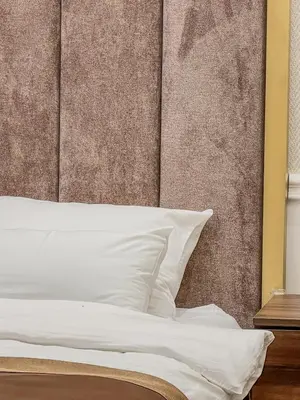 a bed with white pillows next to a wall at Hive Luxury Suites by MN Property in Kotor