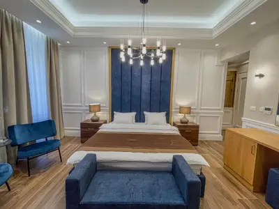 a large bedroom with a large bed and a blue couch at Hive Luxury Suites by MN Property in Kotor