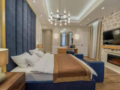a bedroom with a large bed and a fireplace at Hive Luxury Suites by MN Property in Kotor