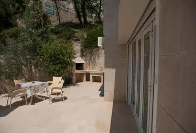 a patio with a table and chairs next to a building at Apartments Villa Simonovic in Petrovac na Moru